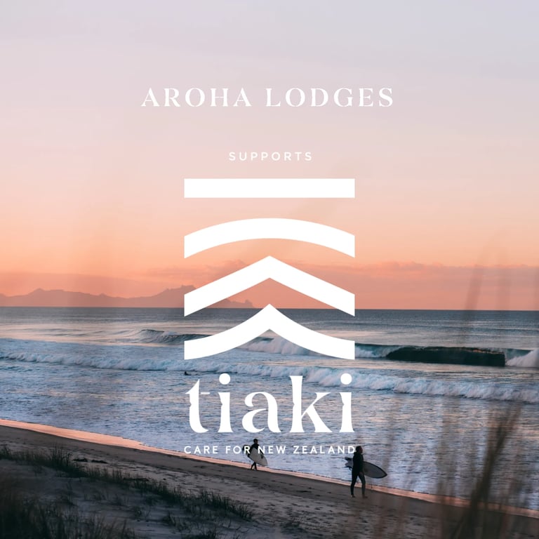 Aroha Lodges supports tiaki logo with surfer at sunset beach, ocean waves and mountains in background